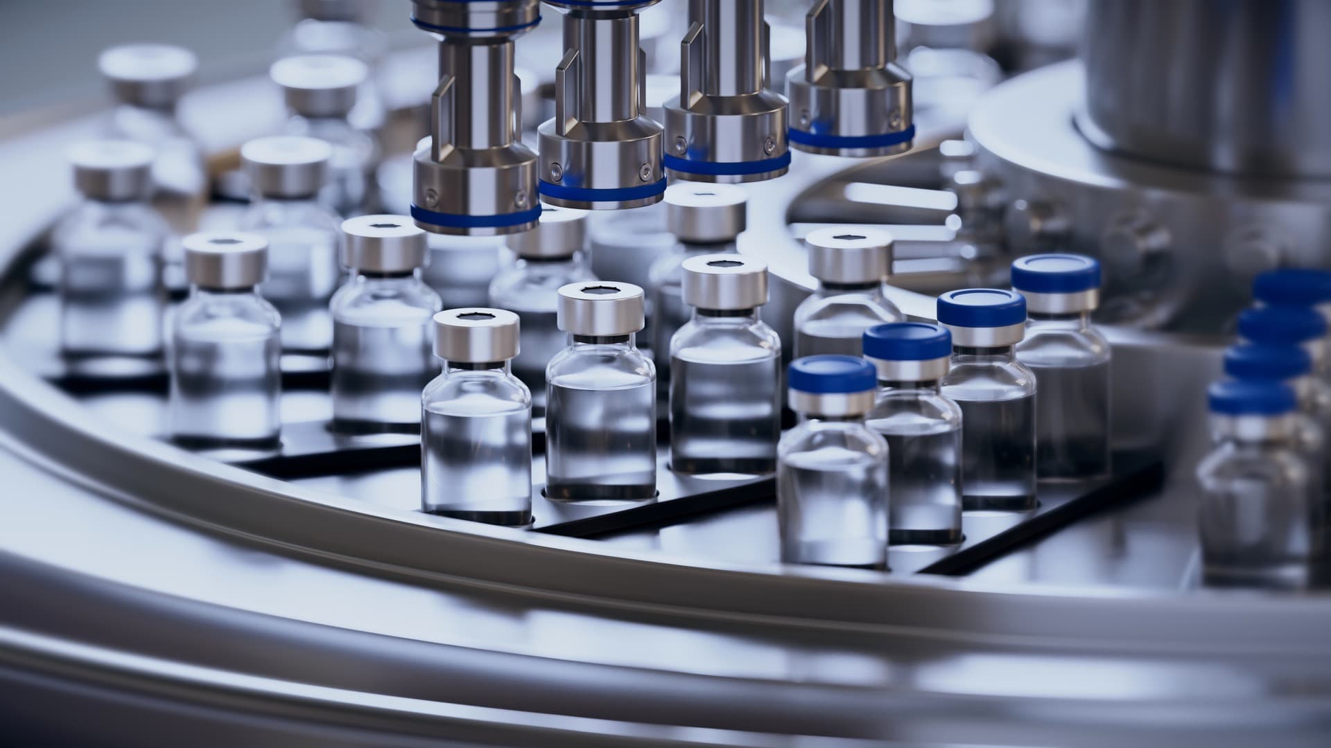 Pharmaceutical vials on an automated filling line inside an industrial laboratory.