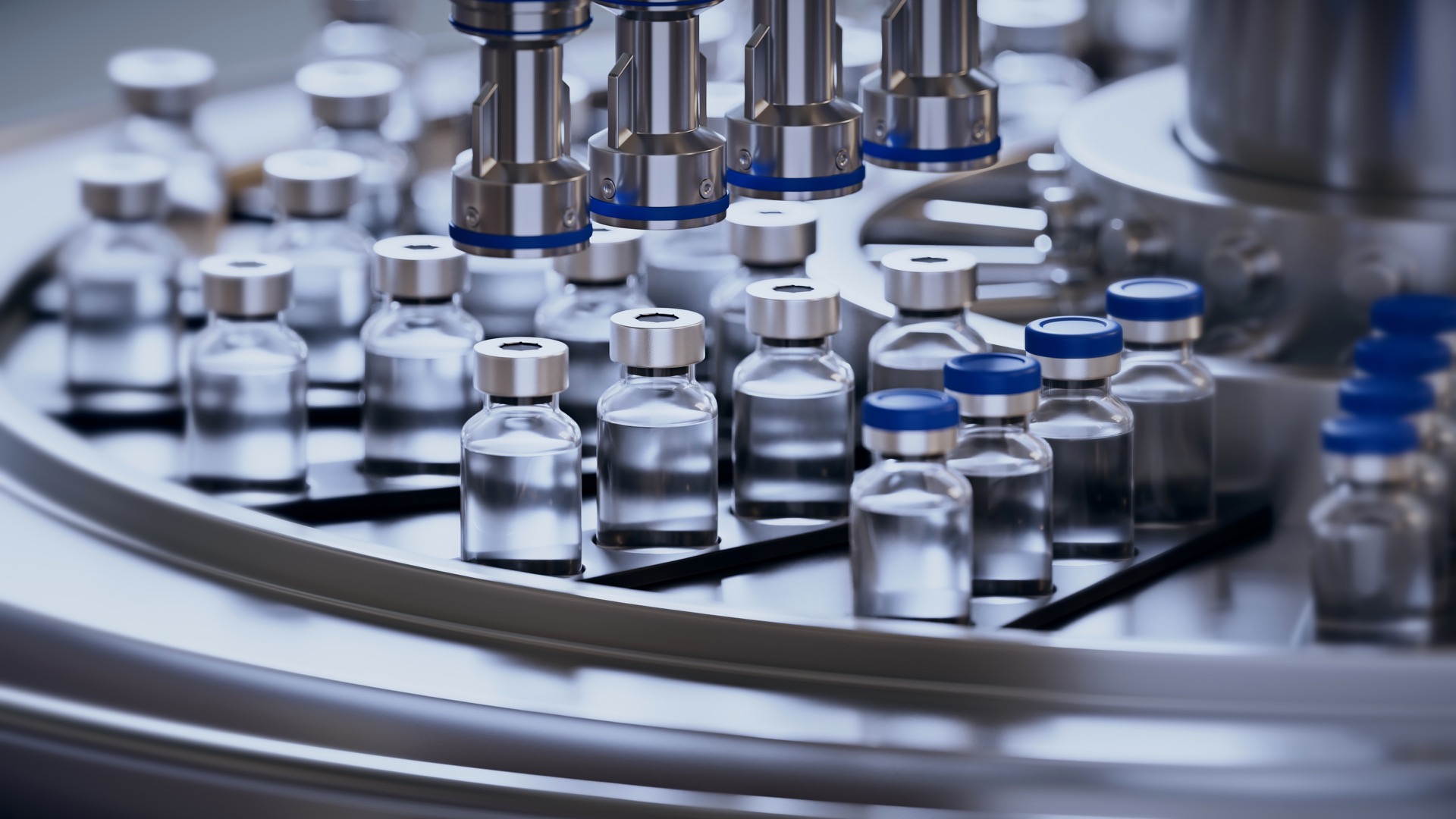Pharmaceutical vials on an automated filling line inside an industrial laboratory.